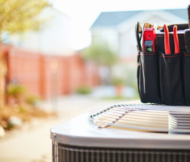 Air conditioner with maintenance tools in residential back yard