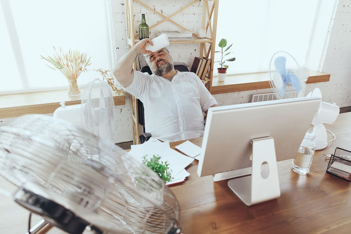 Guy hot in his office surrounded by fans